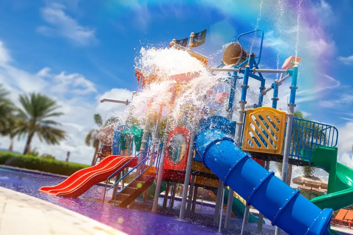 Parque aquático infantil com escorregadores e balde de água